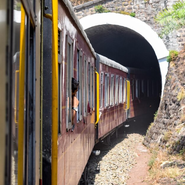 Foto tren de juguete moviéndose en las laderas de las montañas hermosa vista de un lado montaña de un lado valle moviéndose