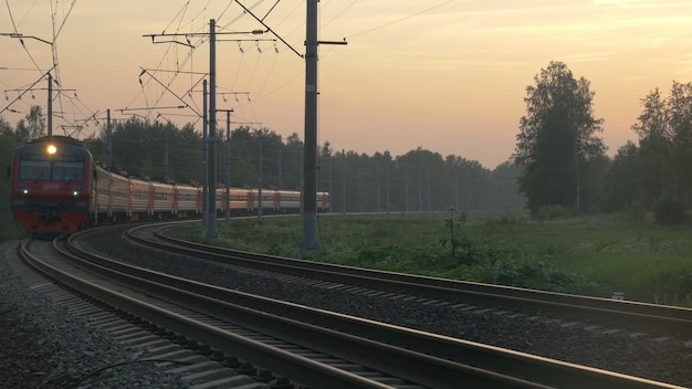 Tren de pasajeros nocturno atravesando el campo. Cerrar vista de carruajes y ruedas a su paso