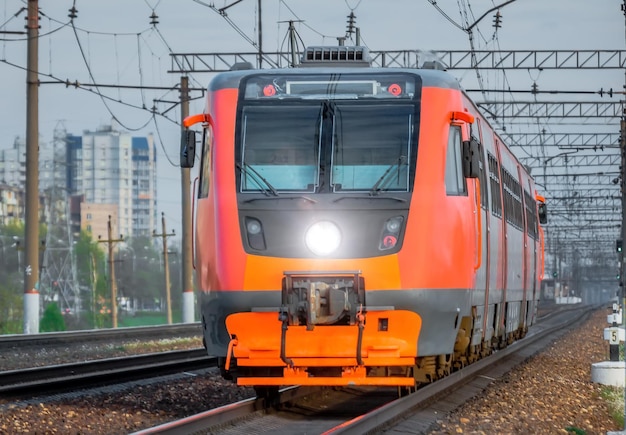Tren de pasajeros rojo de alta velocidad corriendo por el ferrocarril