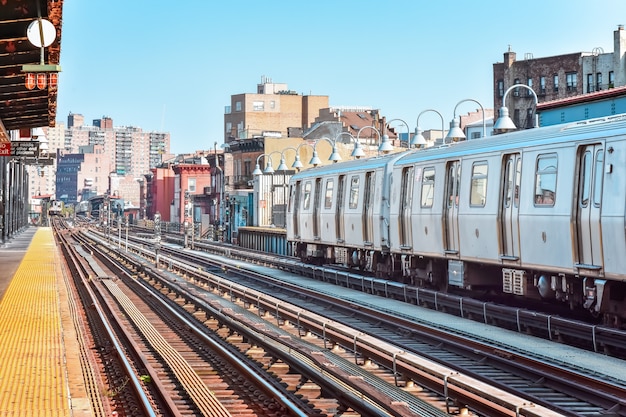 Tren que llega a la estación de la ciudad de Nueva York. Edificios en el fondo, paisaje urbano. Concepto de viaje y tránsito. Manhattan, Nueva York, Estados Unidos.