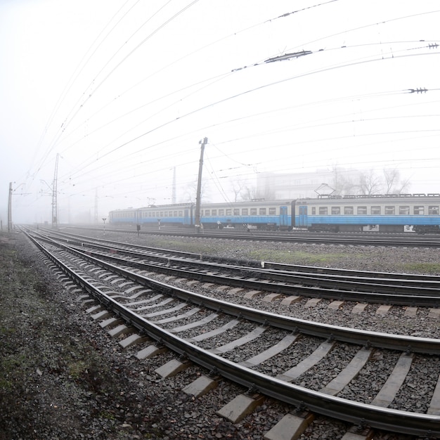 El tren suburbano ucraniano corre a lo largo del ferrocarril en una mañana brumosa