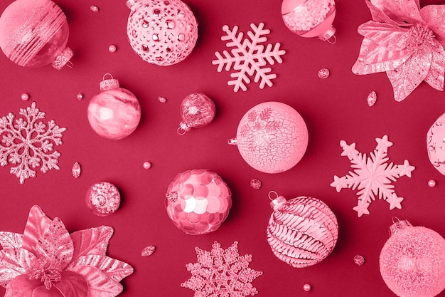 Foto trendige farbe des jahres 2023 feiertagsmuster aus glänzenden weihnachtsdekorationen in viva-magenta-farbe