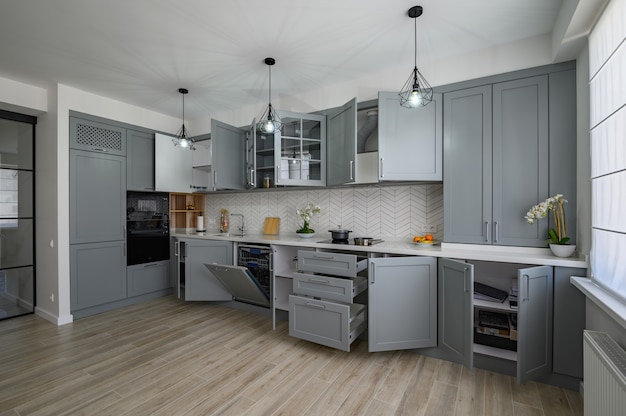 Trendige graue und weiße moderne Küchenmöbel mit offenen Türen