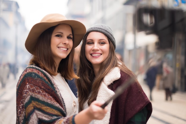 Trendige junge Frauen, die Selfies in der Stadt machen