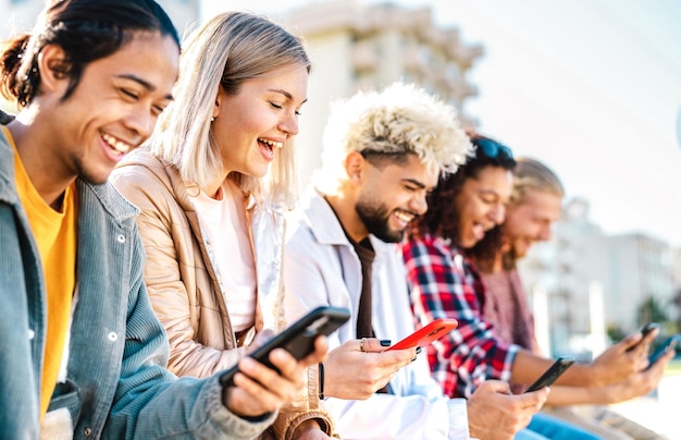 Trendige tausendjährige Freunde, die Smartphones am Campus College verwenden Junge Genz-Leute, die Live-Inhalte mit dem mobilen Smartphone teilen Tech-Lifestyle-Konzept mit immer verbundenen Millennials Heller Filter