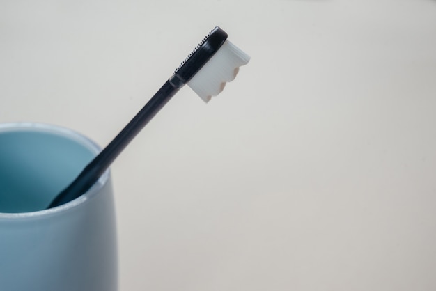 Trendige Zahnbürste mit weichen Borsten im blauen Becher, ultrafeine Zahnbürste mit Nano-Millionen-Borsten, Zahnpflege- und Hygienetrends