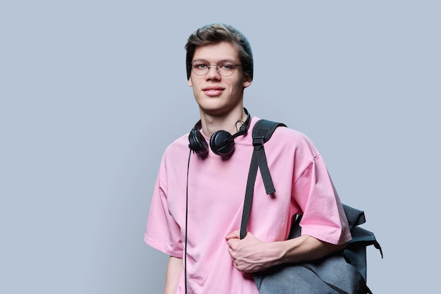 Trendiger junger Hipster in rosa T-Shirt auf grauem Studio-Hintergrund