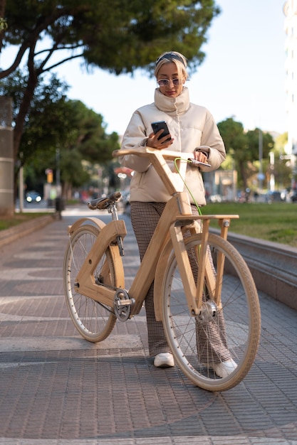 Trendiger Radfahrer mit Handy im Park