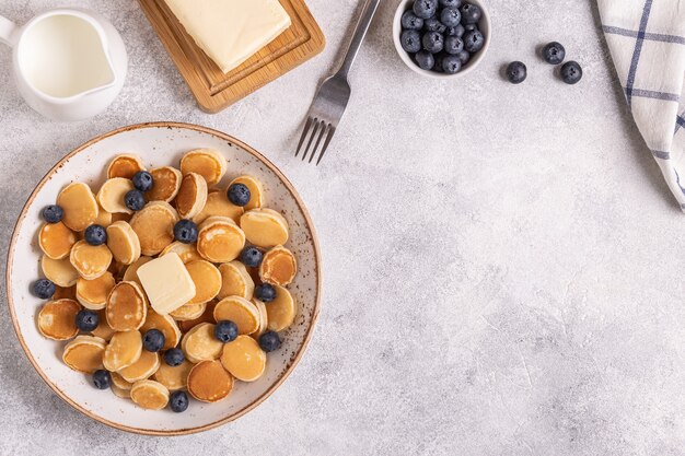 Trendiges Frühstück mit Minipfannkuchen und Blaubeeren, Draufsicht.