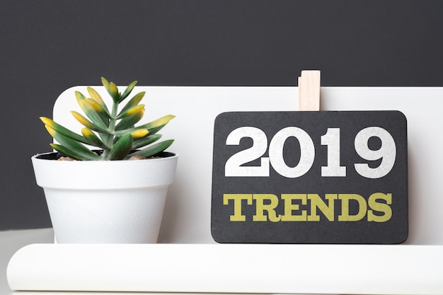 Trends 2019 auf Tafel mit modernem Bleistiftkasten und Grünpflanze