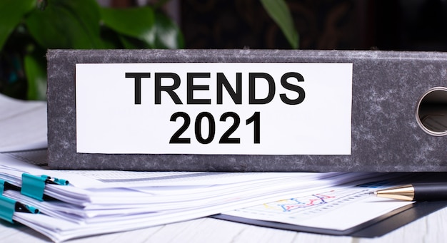 TRENDS 2021 está escrito en una carpeta de archivos gris junto a los documentos. Concepto de negocio