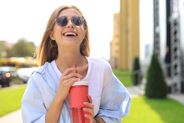 Trendy cooles Hipster-Mädchen-Getränk-Cocktail im städtischen Stadthintergrund.