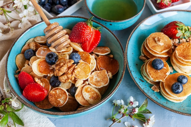 Trendy Food - kleine Pfannkuchen. Poffertjes, kleine holländische Pfannkuchen. Frühstück für Kinder