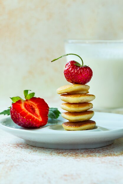 Trendy Food - Pfannkuchen Müsli. Stapel Mini-Müsli-Pfannkuchen mit Erdbeeren und Milch