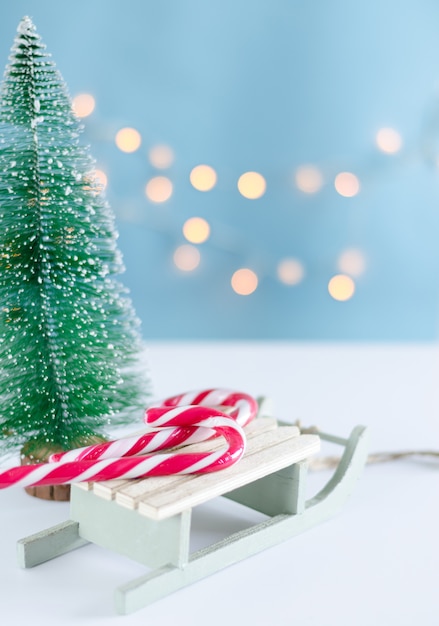 Trenó de madeira com doces e árvore de Natal