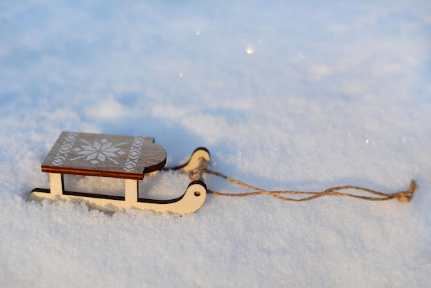 Trenó de madeira em miniatura na neve branca Atividades ao ar livre de inverno Fundo de inverno ou Natal