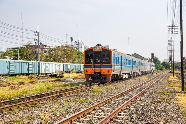 Trens diesel clássicos transportam passageiros e turistas na Tailândia em cruzamentos ferroviários