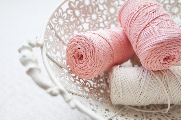 Trenzado de macramé hecho a mano e hilos de algodón en la canasta sobre fondo blanco Cordones de macramé de algodón