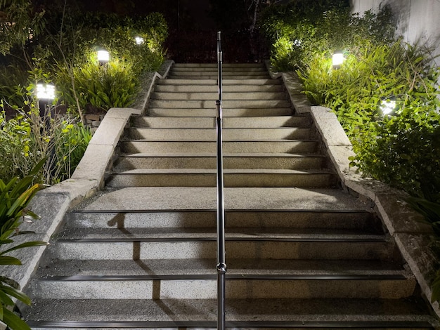 Treppe im Park, mit Beleuchtung auf beiden Seiten und einem Geländer in der Mitte.