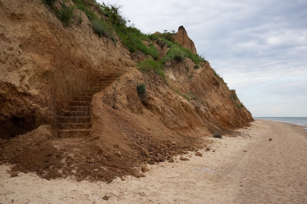 Treppen in den Felsen, Strand und Küste mit steilen Klippen