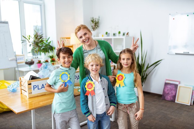 Três alunos diligentes. Professora rindo e três alunos diligentes se sentindo felizes após a aula de ecologia