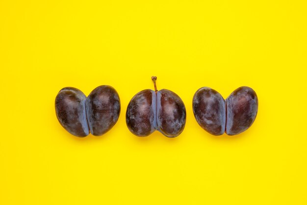 Três ameixas feias com formato de coração em fundo amarelo Frutas e vegetais feios são adequados para foo