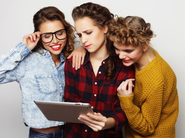 Tres amigas adolescentes tomando selfie con tableta digital, Foto de estudio sobre fondo gris