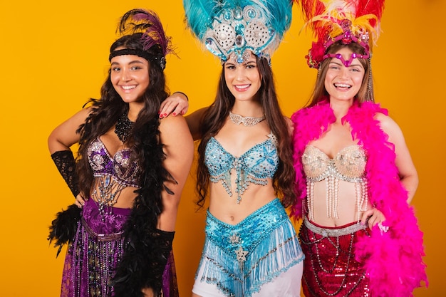 Três amigas brasileiras com roupas de rainha do carnaval da escola de samba Coroa de penas