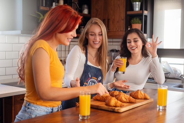 Tres amigas disfrutando juntas del desayuno en casa