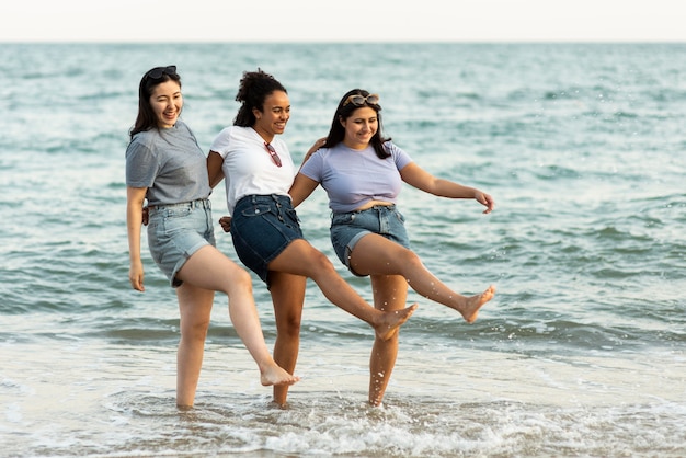 Foto três amigas se divertindo na praia