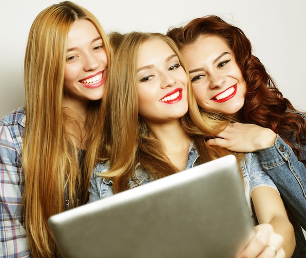 Tres amigas tomando selfie con tableta digital