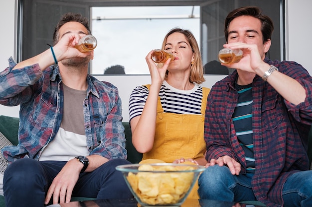 Foto três amigos a beber cerveja e a partilhar momentos de relaxamento e diversão juntos.