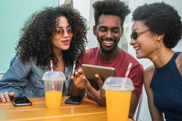 Tres amigos afro con tableta digital