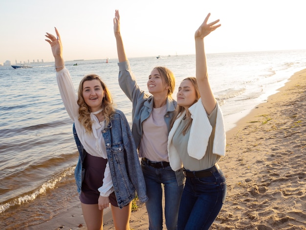 Tres amigos caminan por la playa la felicidad de la comunicación.