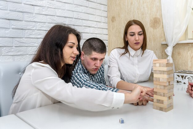 Tres amigos jugando al juego de la torre en el café