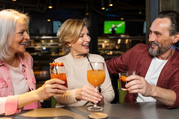 Tres amigos mayores bebiendo en un restaurante