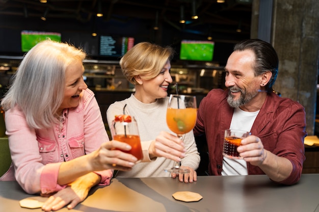 Foto tres amigos mayores bebiendo en un restaurante