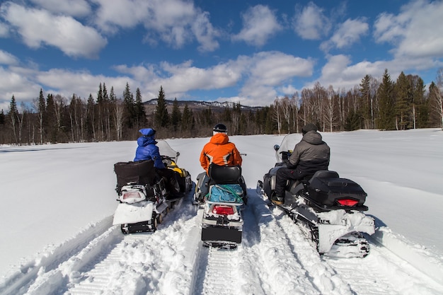 Tres amigos en motos de nieve en las montañas de los Urales del Sur.