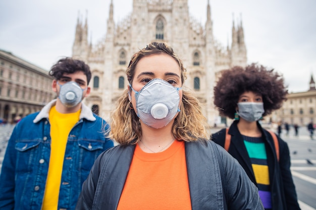 Tres amigos multiétnicos con una máscara médica que protege contra la contaminación y los virus.