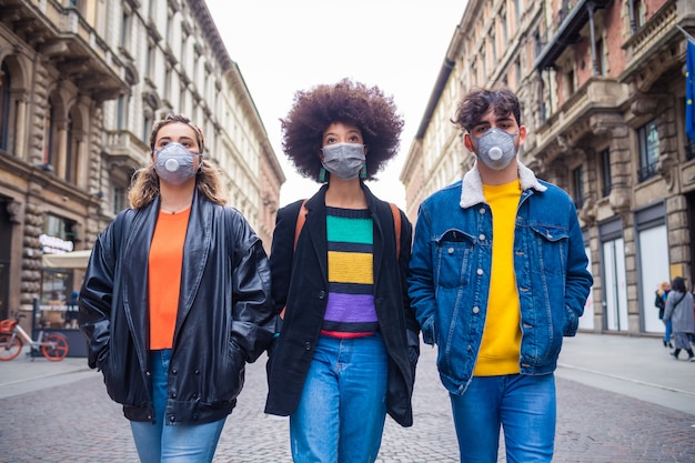 Tres amigos multiétnicos con una máscara médica que protege contra la contaminación y los virus.