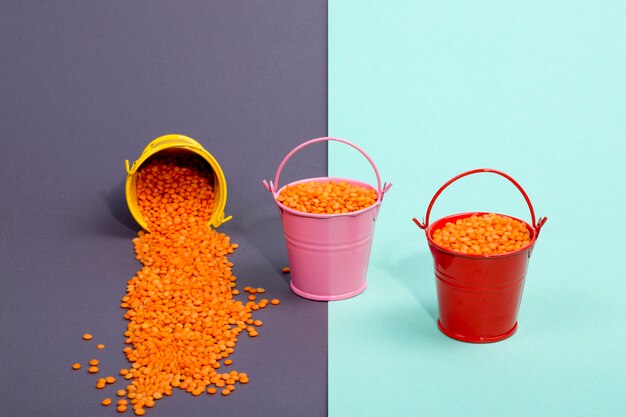 Três baldes multicoloridos com laranja lentilha