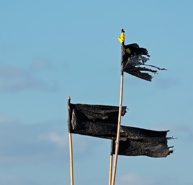 Foto tres banderas negras hechas de plástico