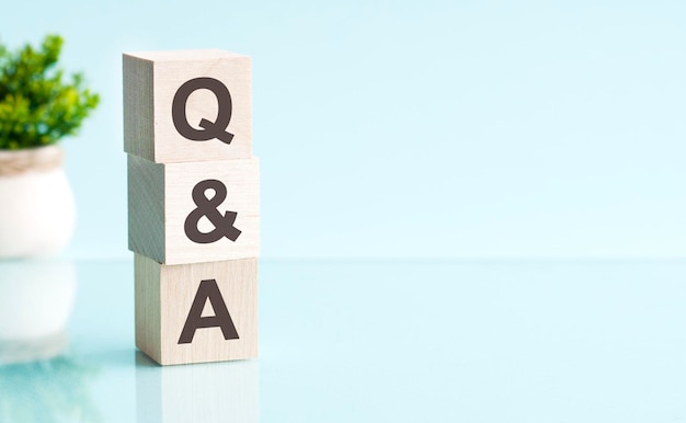 tres bloques de madera con las letras Q y A en la mesa azul brillante Q y A abreviatura de pregunta y respuesta