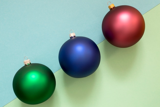 Tres bolas de árbol de navidad en una pared multicolor