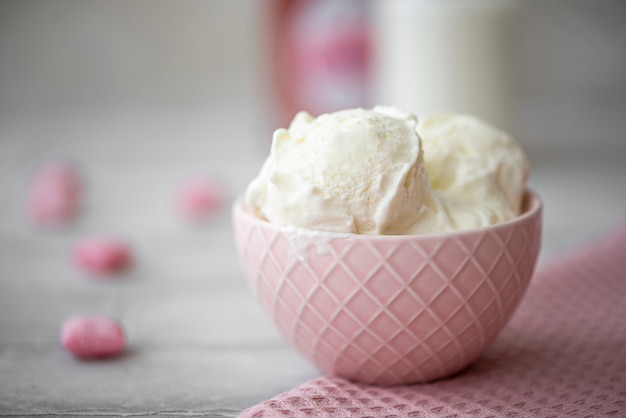 Tres bolas de helado de crema blanca en un tazón rosa
