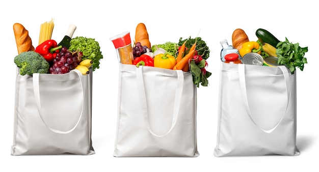 Tres bolsas blancas con diferentes alimentos, frutas y verduras.