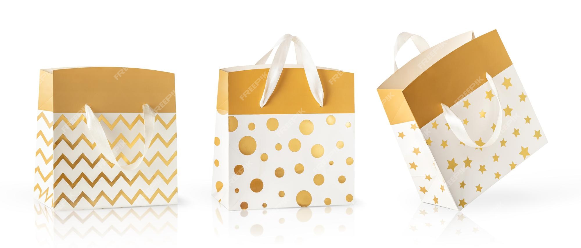 Tres bolsas papel doradas diferentes para regalos aisladas en fondo blanco. | Foto Premium