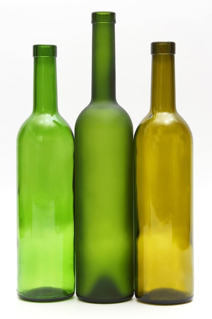 Tres botellas de vino vacías sobre fondo blanco. utensilios para beber