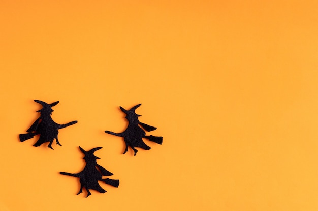 Tres brujas negras sobre fondo naranja de Halloween
