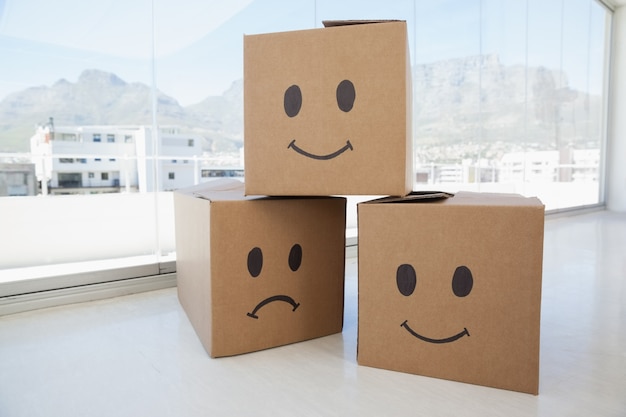 Foto três caixas de papelão com sinais de smiley contra a janela